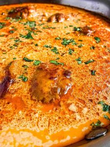 Creamy Coconut Milk Chicken Thighs in Skillet Side Angle