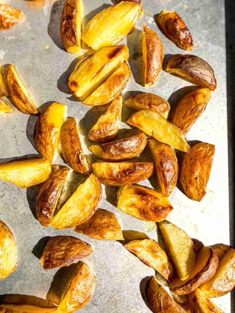overhead view of crispy potatoes on a baking sheet