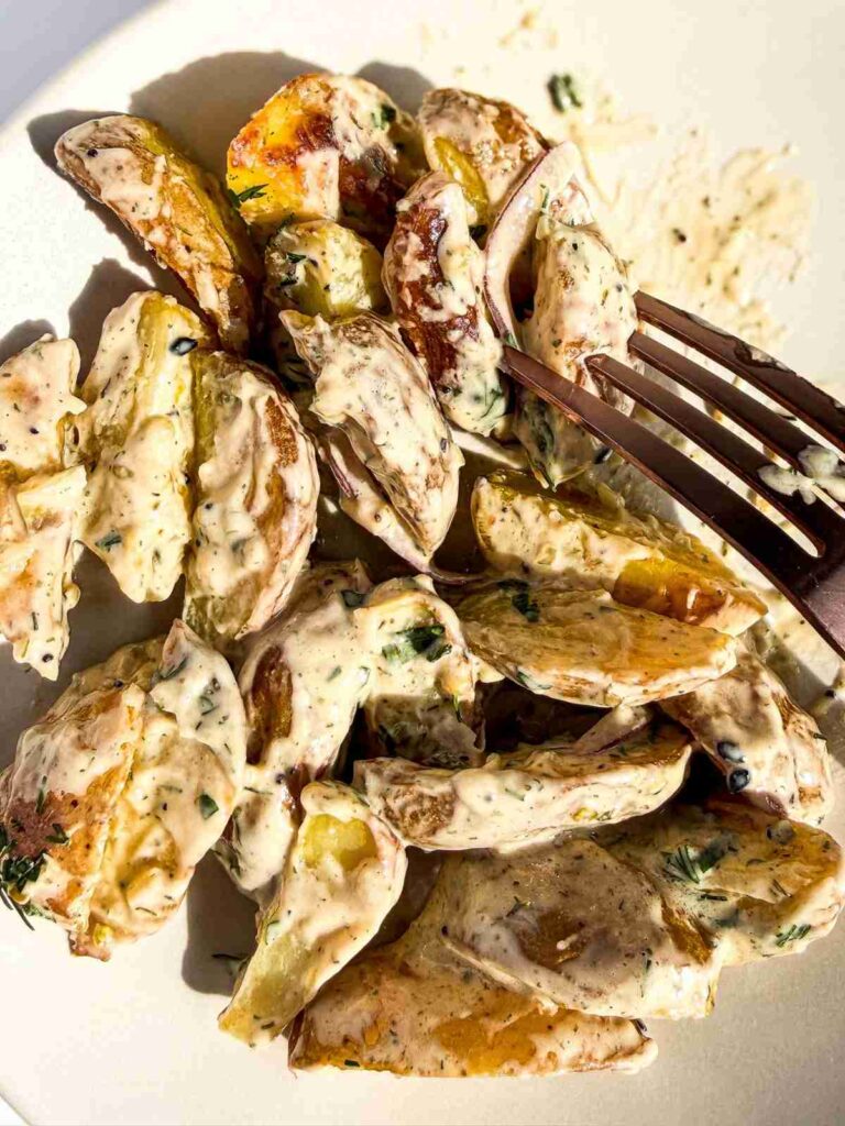 overhead view of forkful of crispy potatoes with everything dill tahini