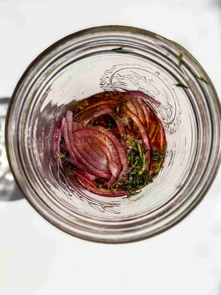 mixed red wine vinegar and olive oil in a glass container for Greek Potato Salad