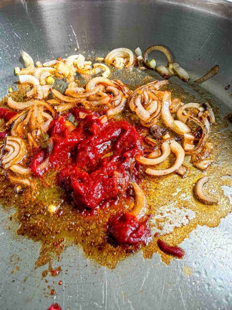 Healthy Leftover Rotisserie Chicken and Rice overhead view of tomato paste and shallots in skillet