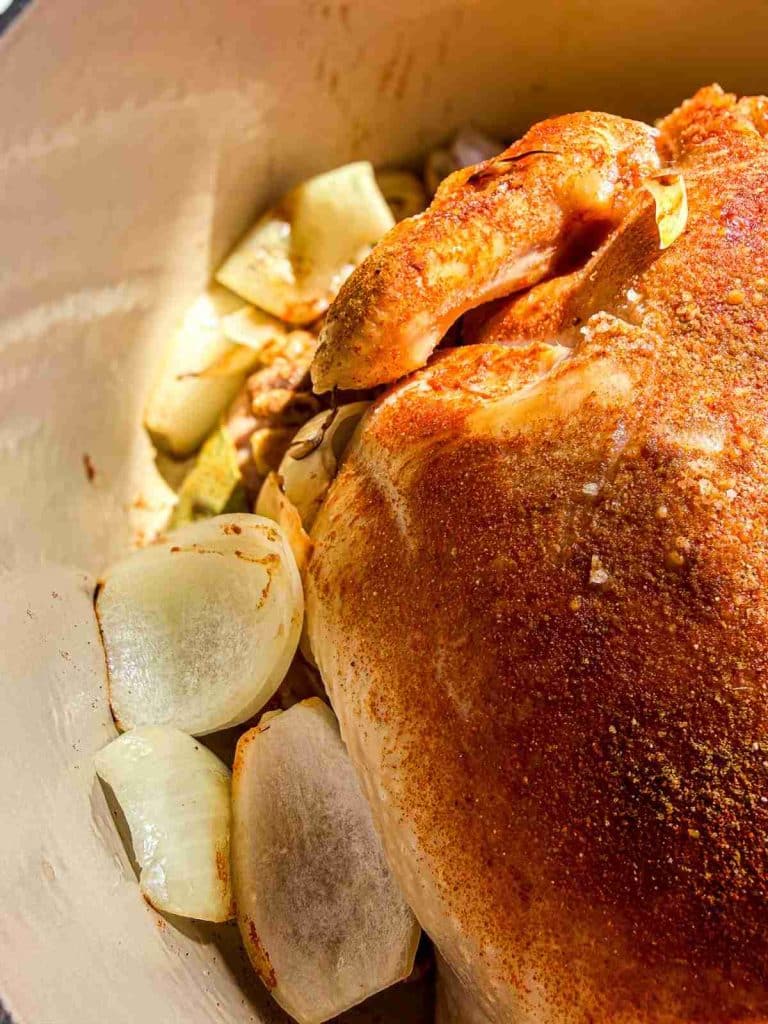 overhead view of seasoned chicken in the dutch oven