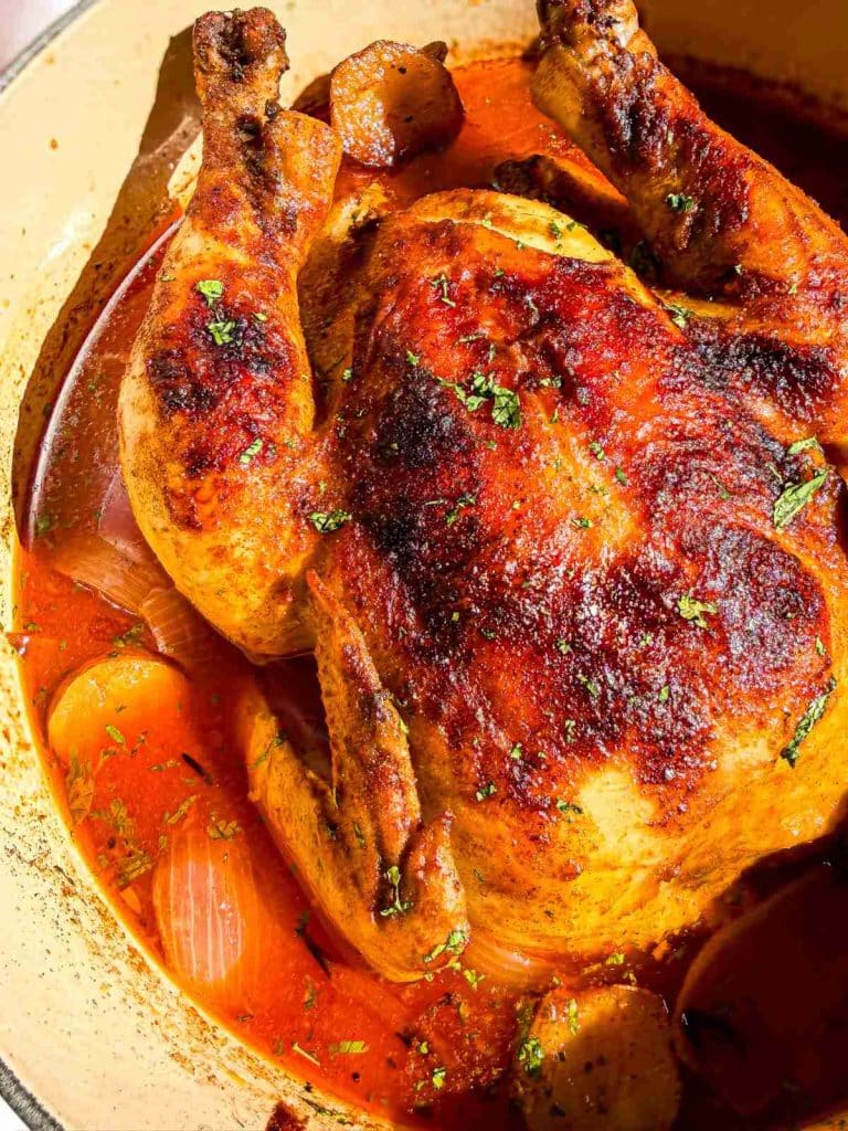 overhead view of Pot Roast Chicken Tomato Broth in a dutch oven
