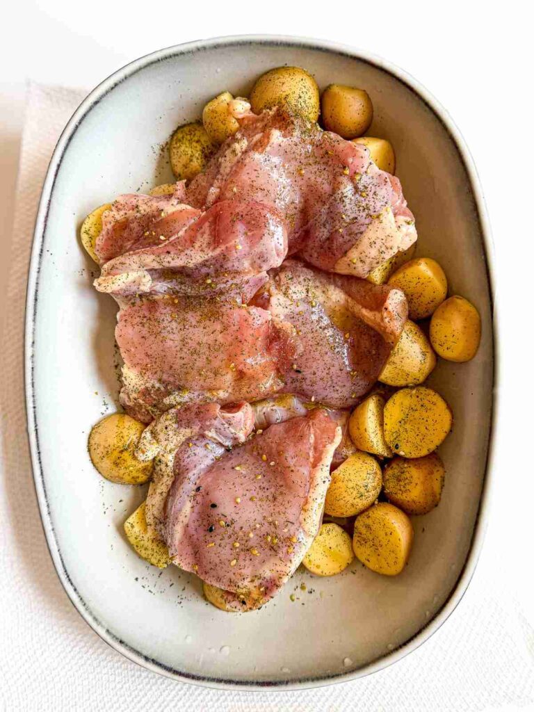 overhead view of Lemon Dill Baked Chicken Thighs and Potatoes in a baking dish