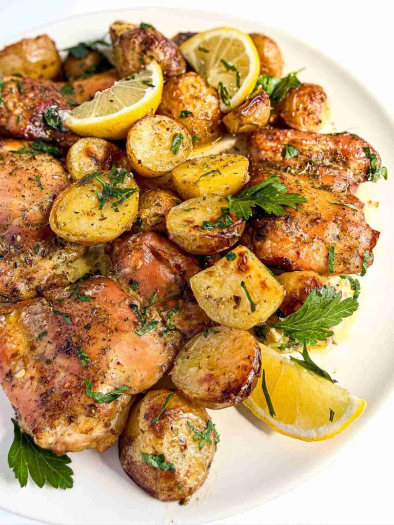 side angle of Lemon Dill Baked Chicken Thighs and Potatoes on a plate
