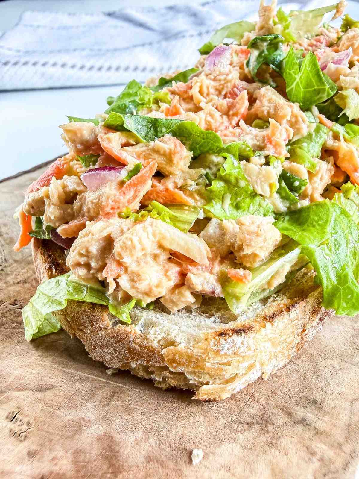 best tuna salad recipe with shredded carrots and chopped onions on a slice of italian sourdough bread