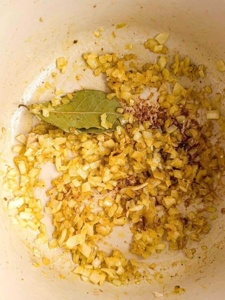 overhead view of diced onions cooking in Dutch oven