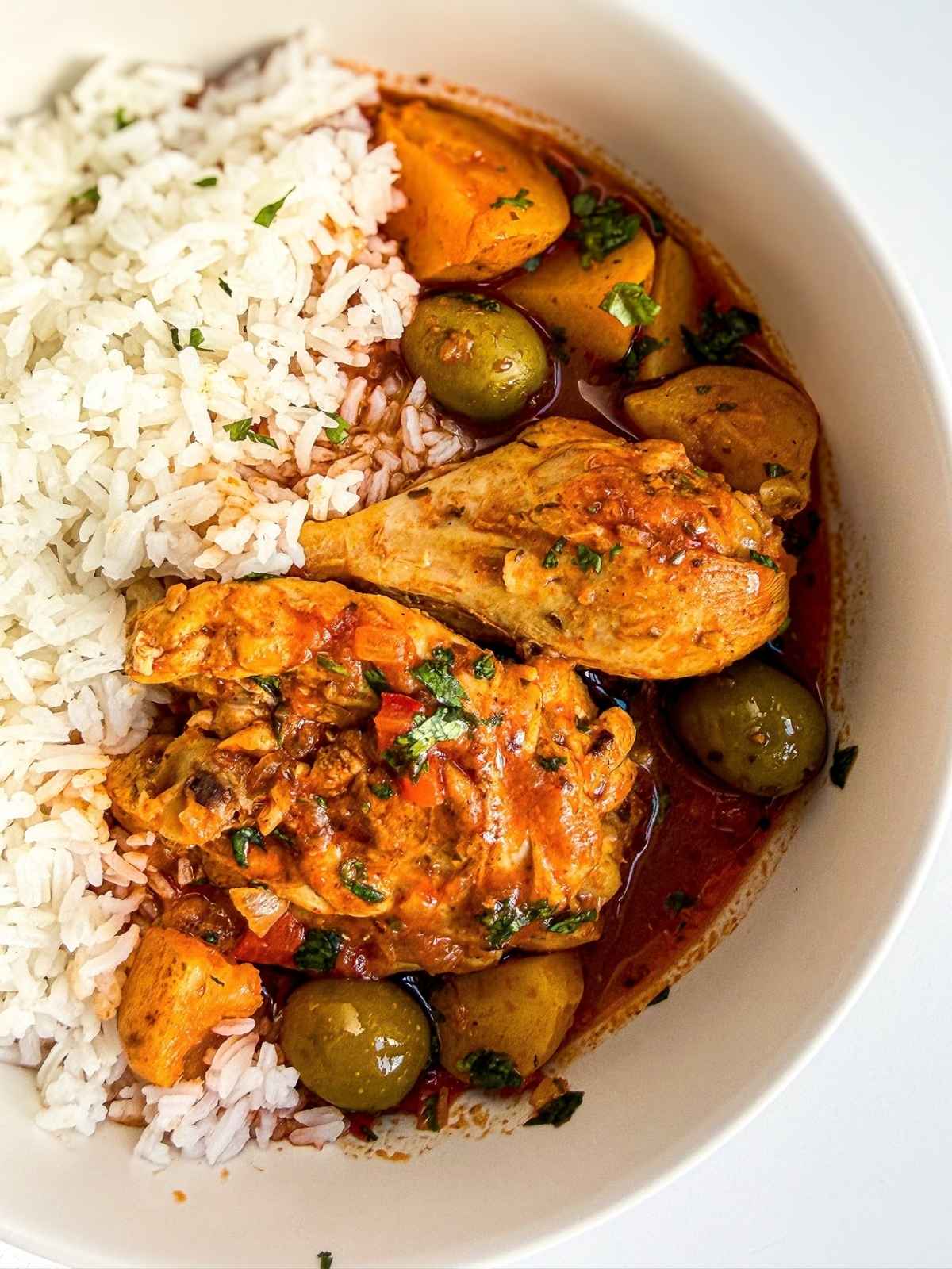 overhead view of a bowl of pollo guisado with white rice