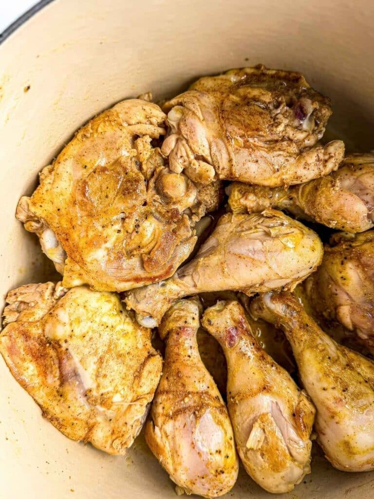 overhead view of seared chicken in Dutch oven